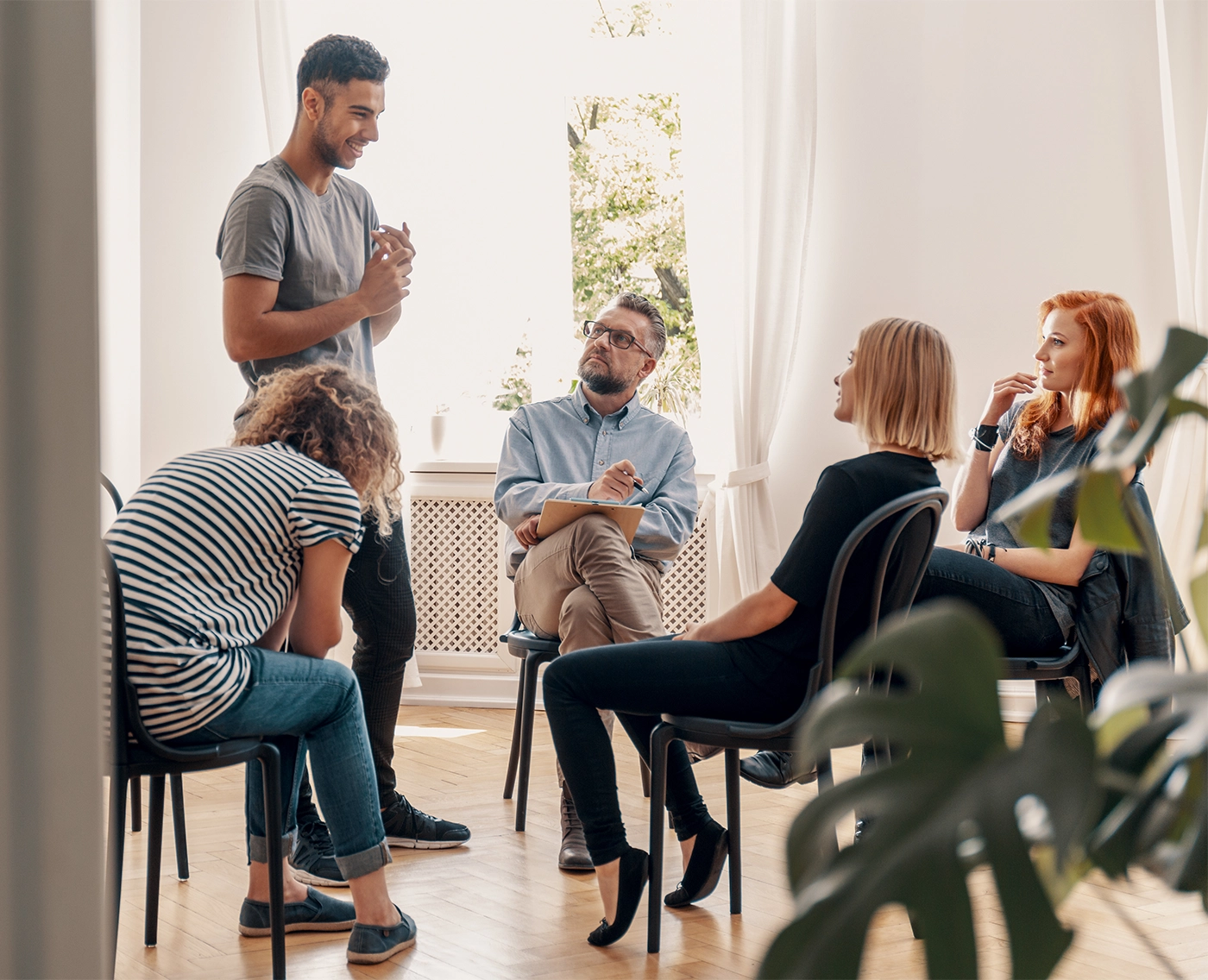 Happy hispanic man talking to his support group about his successful fight with drug addiction