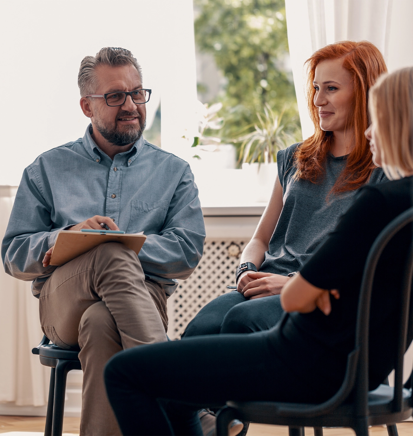 Smiling spanish man talking to his friends during meeting for teenagers with therapist