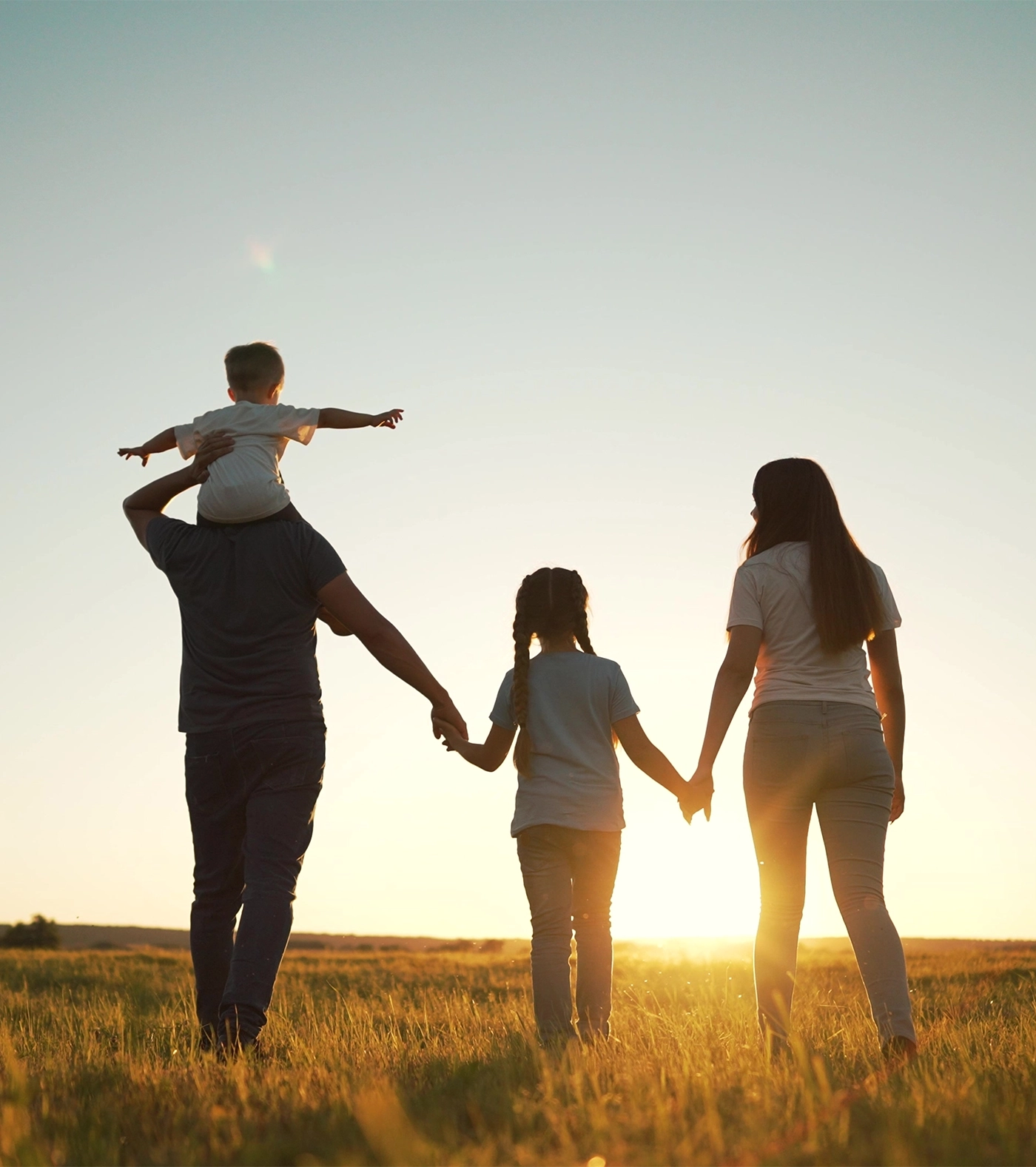 Happy family walk in field in nature.Parents and children are free and active people in nature.Healthy and cheerful family at picnic in the park.Summer walk in the park at sunset.Parents and children