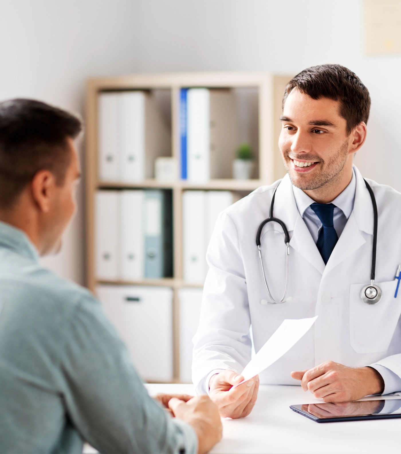 happy smiling doctor giving prescription to patient at medical office