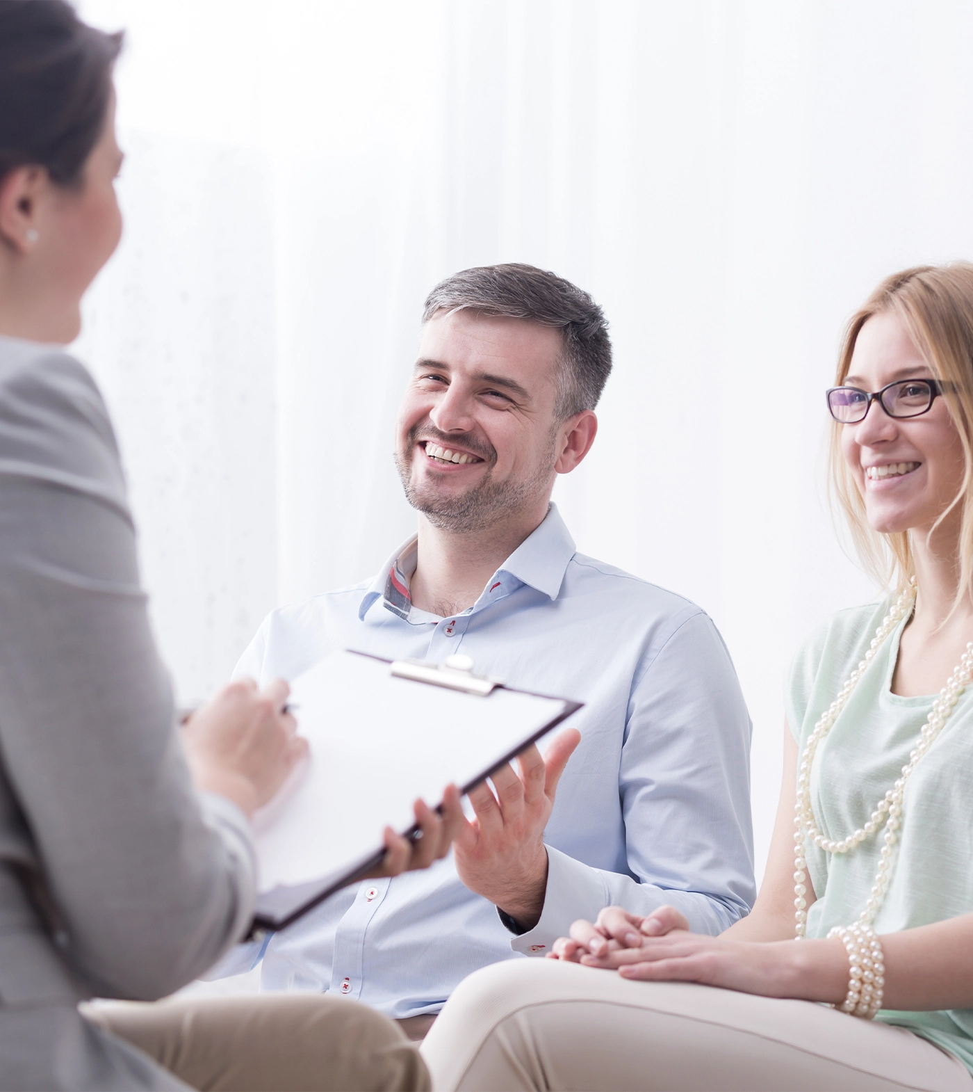 Psychotherapist filling in questionnaire on psychotherapy session with happy young marriage