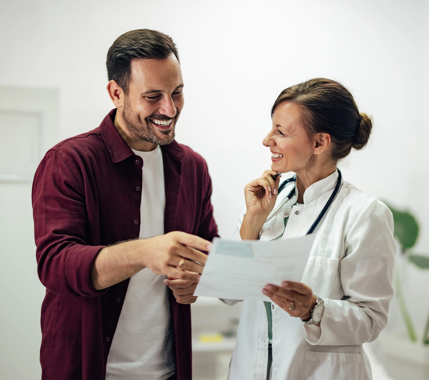 A healthcare professional and patient discussing medical test results in a bright clinic