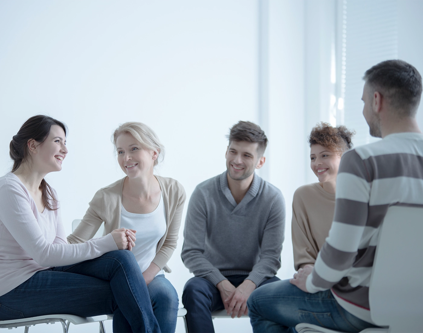 Smiling girl talking about her fight against addiction during meeting with support group