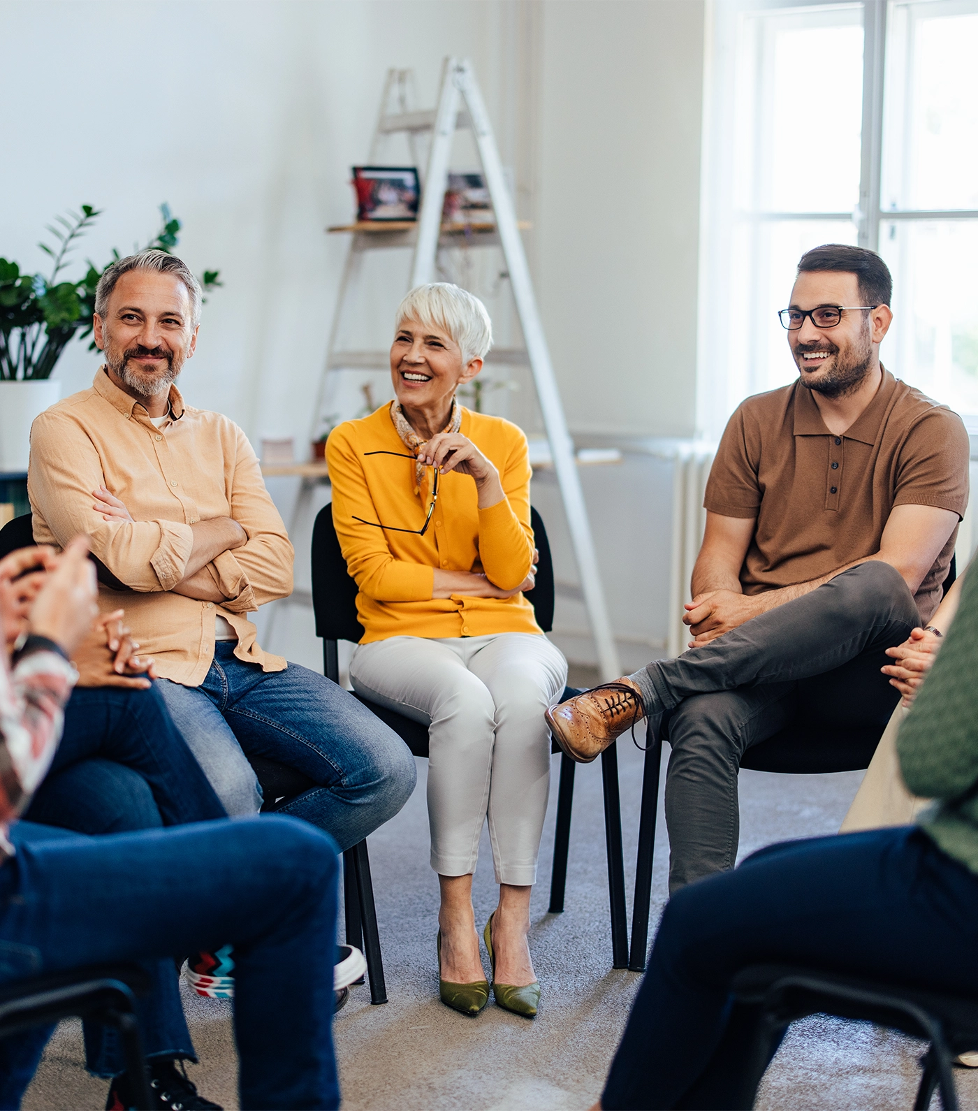 Engaged adults sitting in a circle sharing thoughts and ideas in a discussion