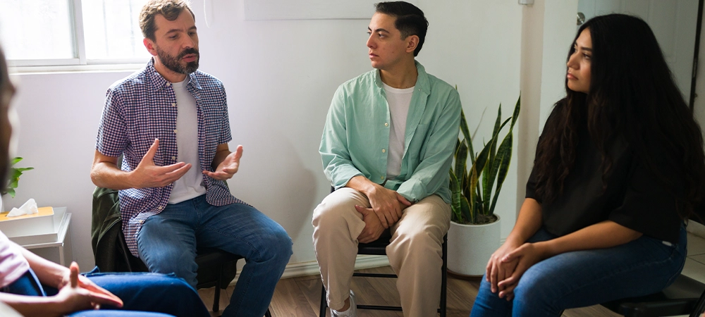 Hopeful people sitting in a circle, sharing experiences and offering support during a mental health group session
