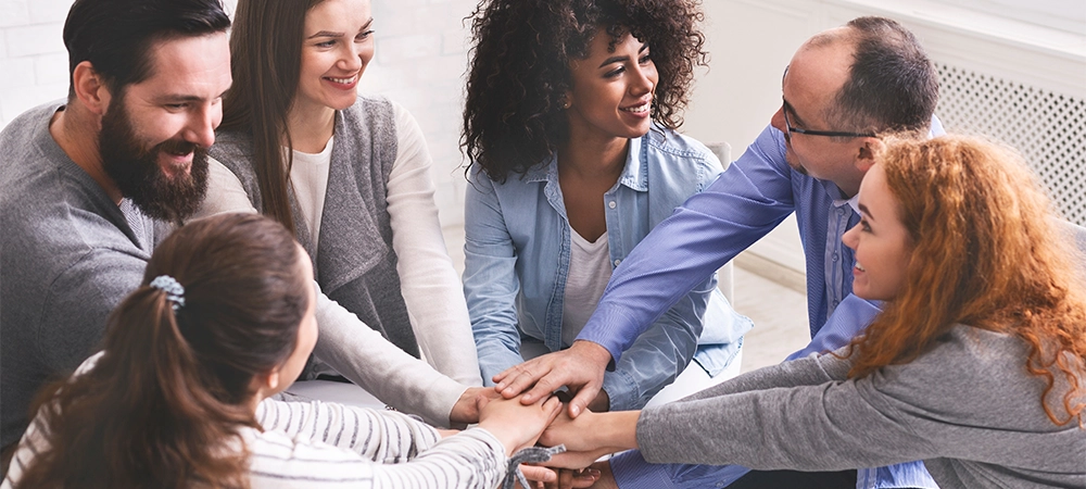 Team Spirit And Cooperation Concept. Group Of Happy People Joining Hands At Therapy Session, Celebrating Common Progress, Supporting Each Other