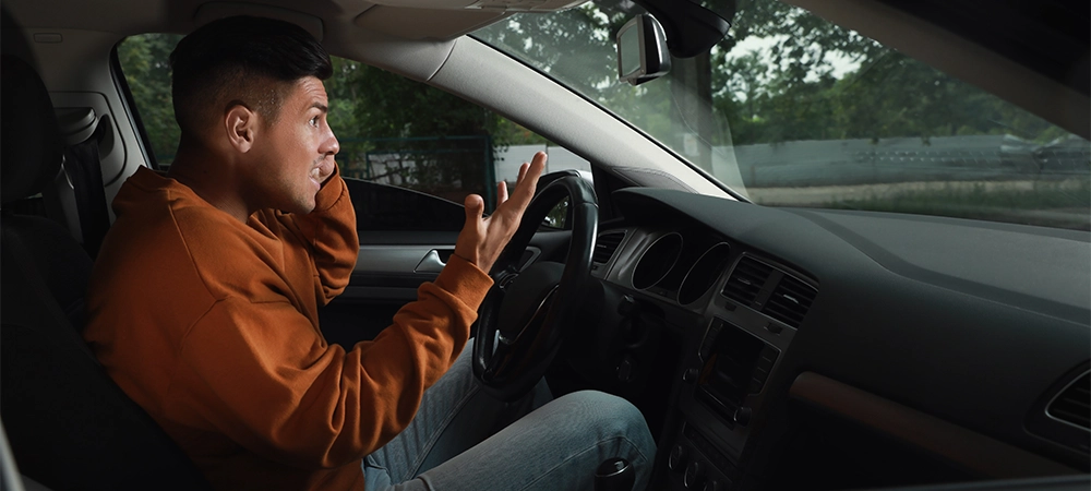Stressed man in driver's seat of modern car
