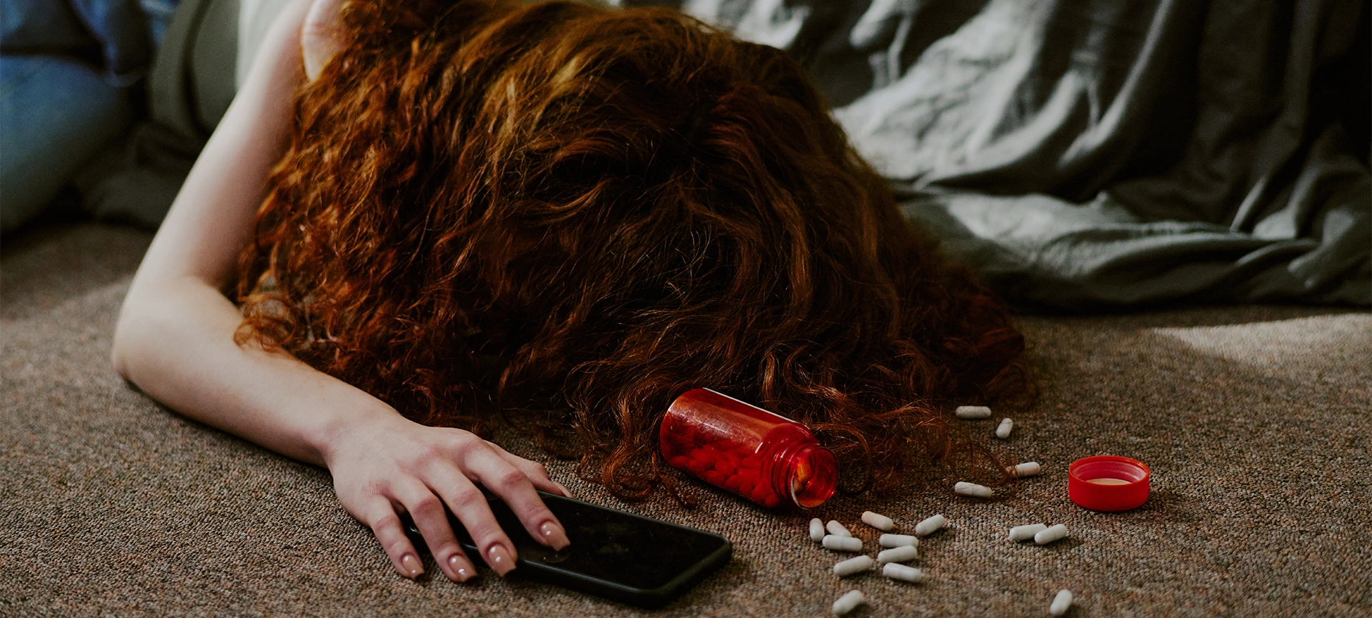 Overdosing Young Woman on Carpet with Pills Scattered