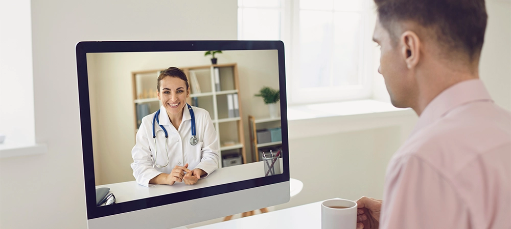 Online doctor. A young businessman is sitting in his office and uses the services of an online doctor.